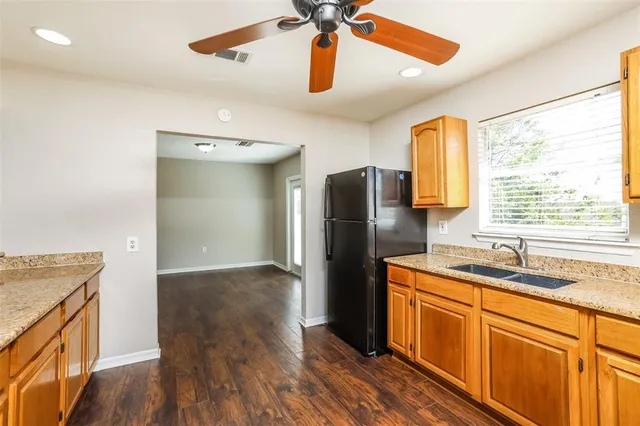 a kitchen with stainless steel appliances granite countertop a refrigerator a sink and a stove