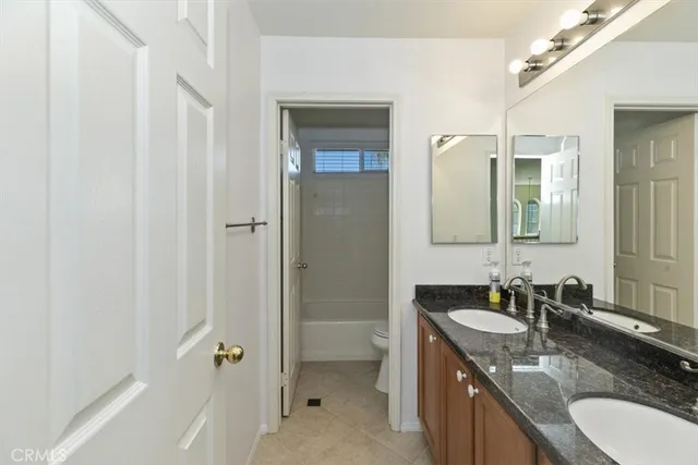 a bathroom with a granite countertop sink tub and shower