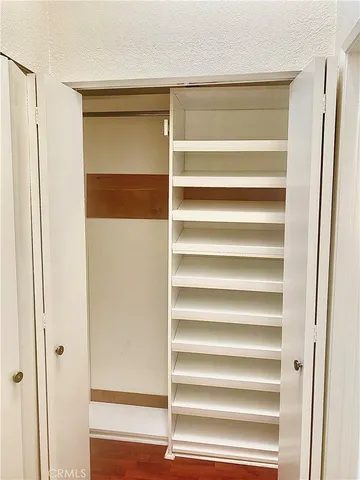 a view of walk in closet with empty racks