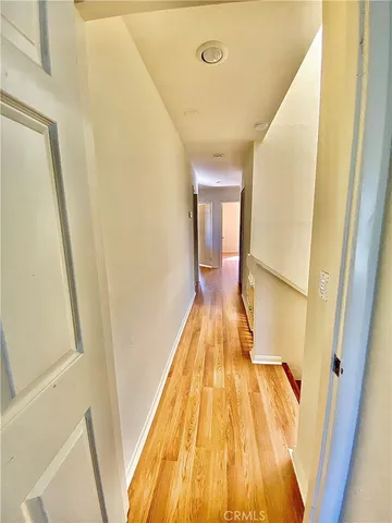 a view of a hallway with wooden floor and staircase