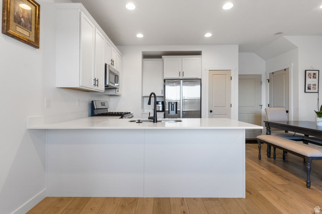 3473 Hardman Way Lehi, UT 84048 - Photo 9 of 22 Kitchen featuring white cabinets, a peninsula, recessed lighting, stainless steel appliances, and light wood-style flooring