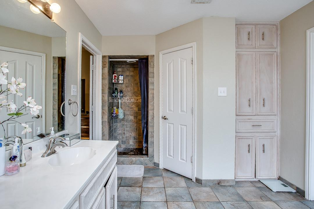 6032 79th Street Lubbock, TX 79424 - Photo 14 of 19 a spacious bathroom with a tub shower and sink