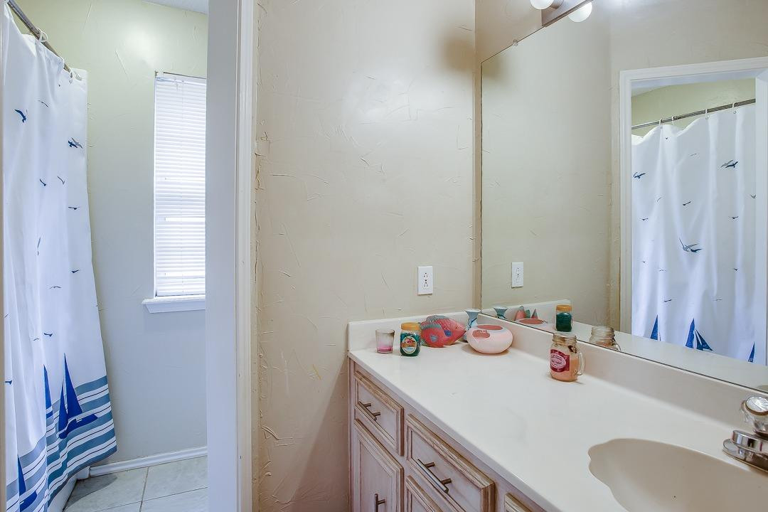 6032 79th Street Lubbock, TX 79424 - Photo 17 of 19 a bathroom with a sink and a mirror