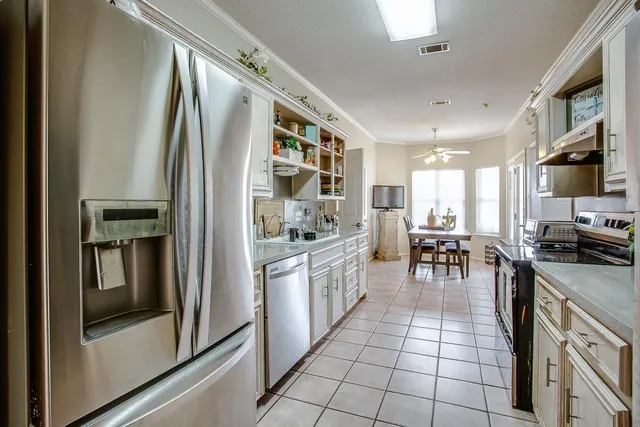 a kitchen with stainless steel appliances granite countertop a refrigerator and a stove
