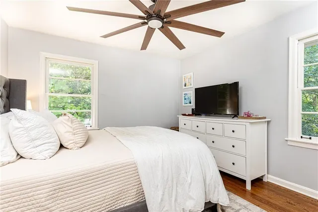 a bedroom with a bed a flat screen tv and a window
