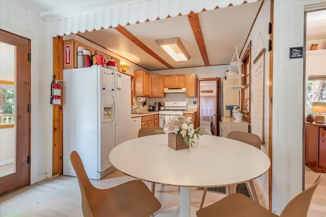 a dining room with stainless steel appliances a dining table and chairs