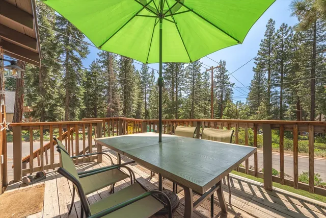 a view of a balcony with chairs and umbrella