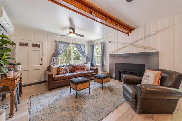 a living room with furniture a fireplace and a large window