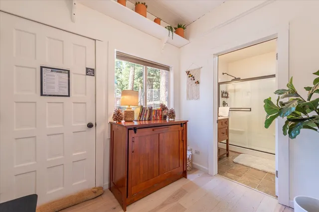 a view of hallway with window and wooden floor