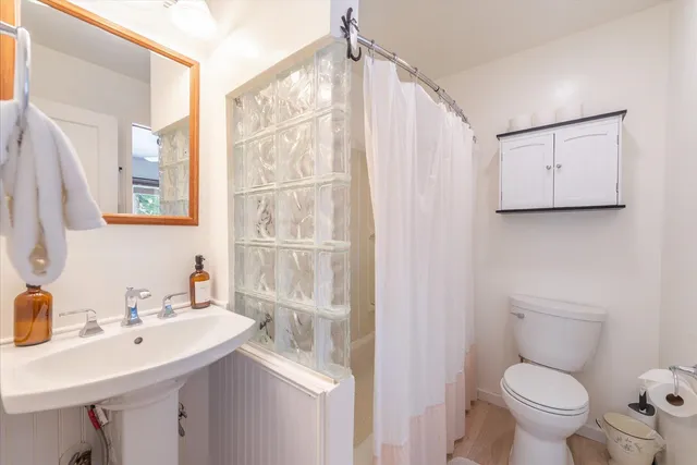 a bathroom with a sink toilet and mirror
