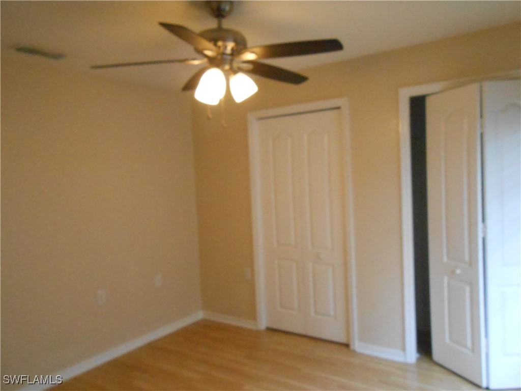 9409 Ivy Brook Run, Unit 1303 Fort Myers, FL 33913 - Photo 17 of 25 a view of a chandelier fan and hardwood floor