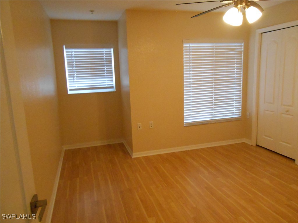 9409 Ivy Brook Run, Unit 1303 Fort Myers, FL 33913 - Photo 22 of 25 a view of an empty room with wooden floor and a window