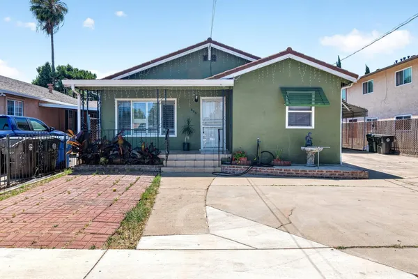 a front view of a house with a yard and potted plants