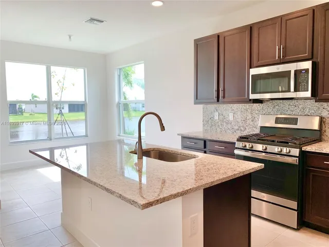 a kitchen with stainless steel appliances granite countertop a sink and a microwave