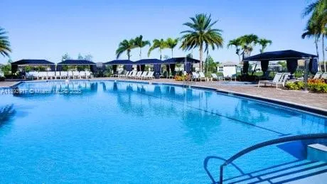 a view of swimming pool with outdoor seating and a garden