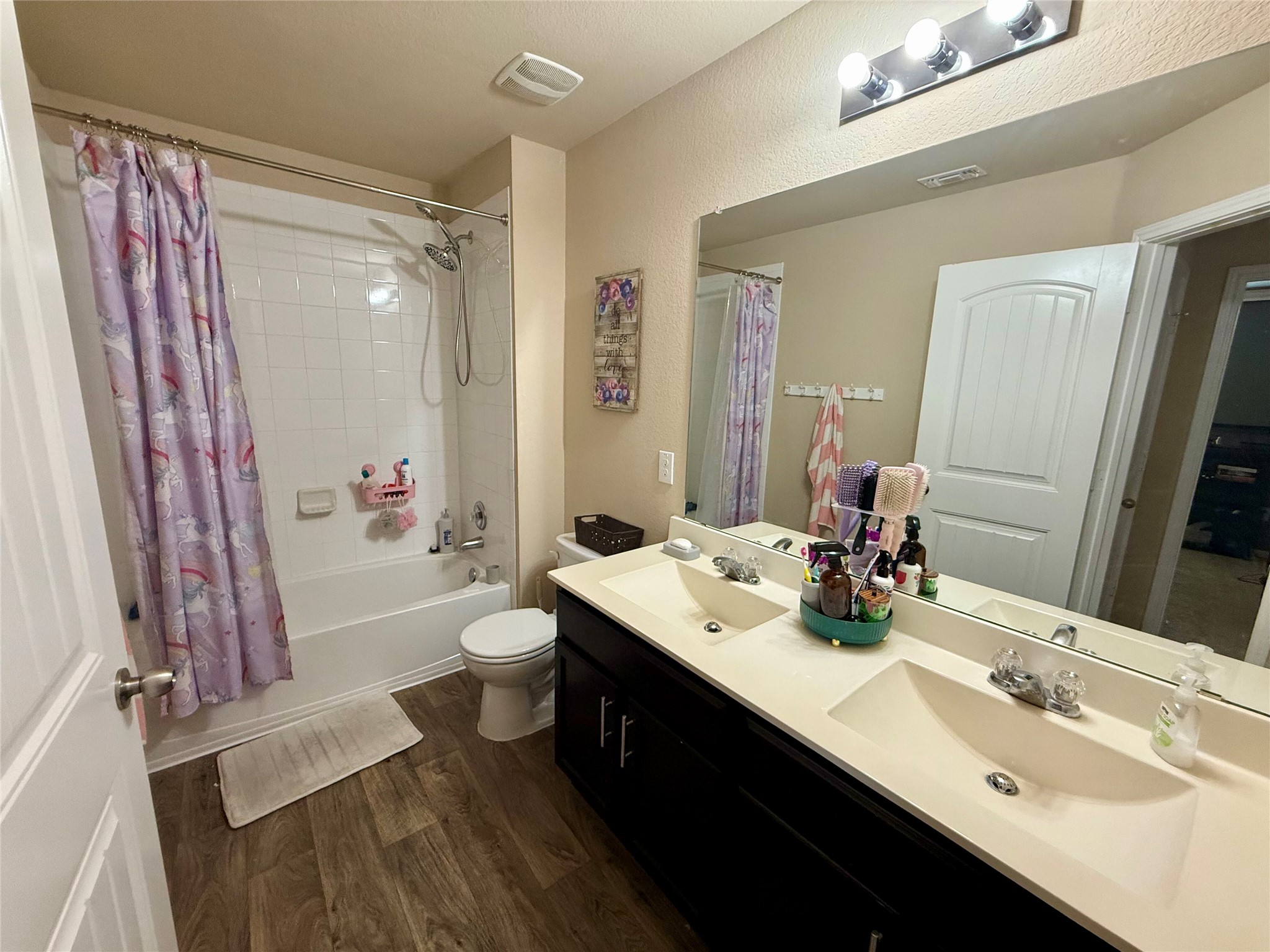 11700 Andesite Road Manor, TX 78653 - Photo 21 of 32 Dual vanities and a full shower-tub combination create a functional bathroom space.