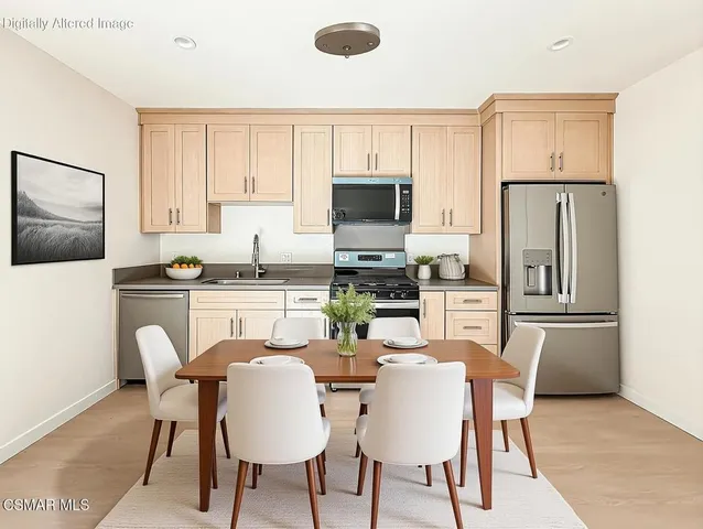 a kitchen with stainless steel appliances a refrigerator a stove a dining table and chairs