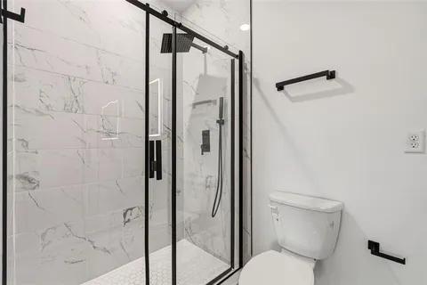 a bathroom with a toilet and a shower