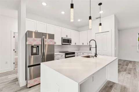 a kitchen with stainless steel appliances a refrigerator sink and microwave