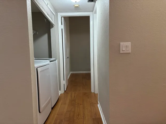 a view of a hallway with wooden floor