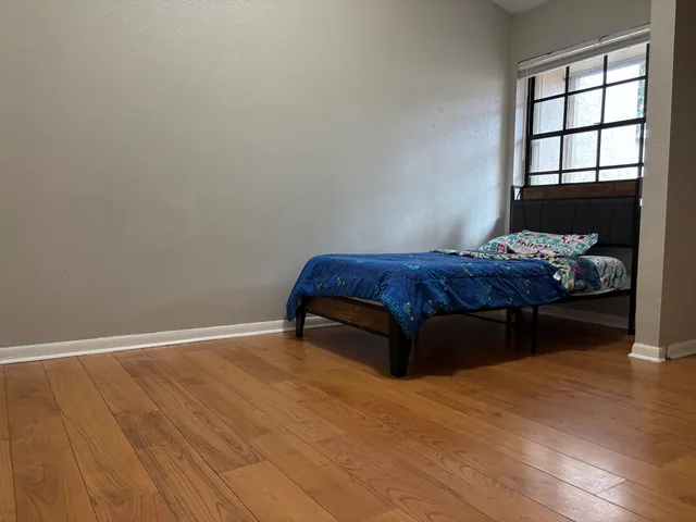 a bedroom with a bed and a window