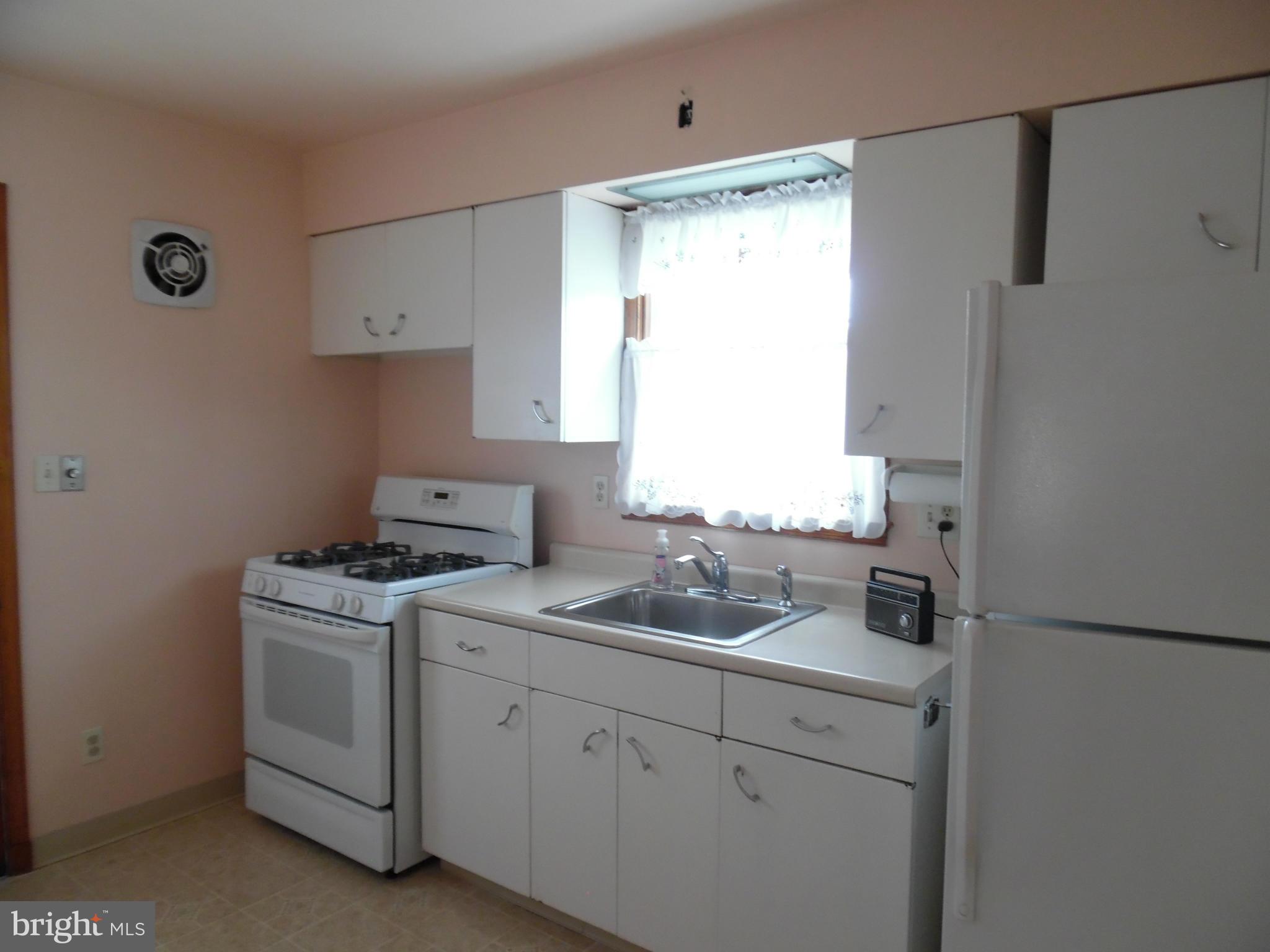 1800 Forrest Road Baltimore, MD 21234 - Photo 6 of 17 a kitchen with white cabinets and white appliances