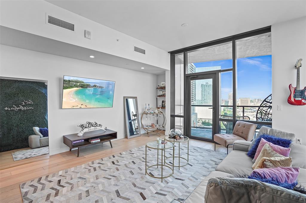 Living room with floor to ceiling windows and wood finished floors