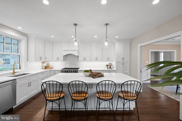 a kitchen with a dining table chairs stove and cabinets