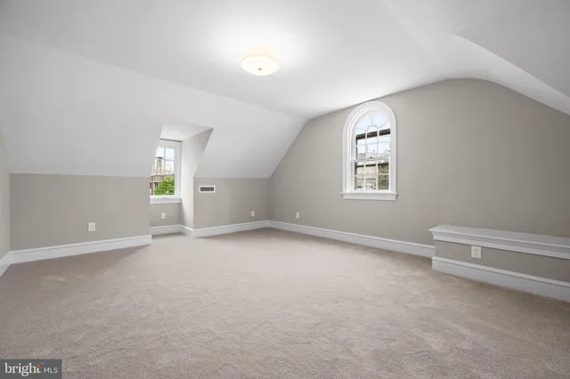 a view of a house with a small yard plants and large tree