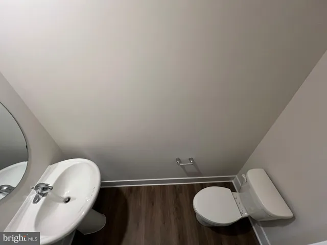 a bathroom with a toilet mirror and sink