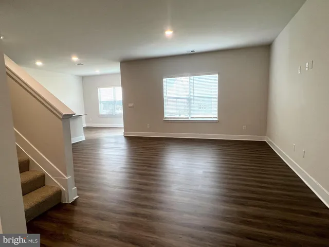 an empty room with wooden floor and windows with wooden floor