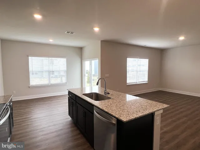 a kitchen with granite countertop sink stove and granite counter top
