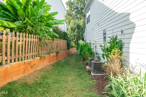 a view of a white house with potted plants