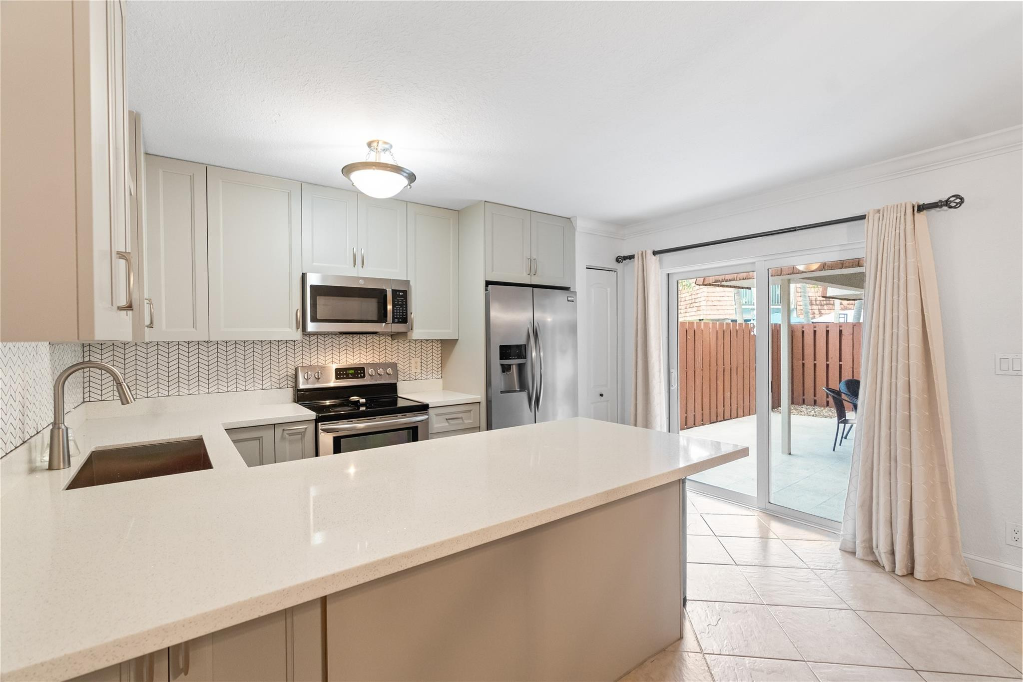 2061 Southwest 90th Avenue, Unit B17 Davie, FL 33324 - Photo 12 of 38 a kitchen with granite countertop a refrigerator and a sink