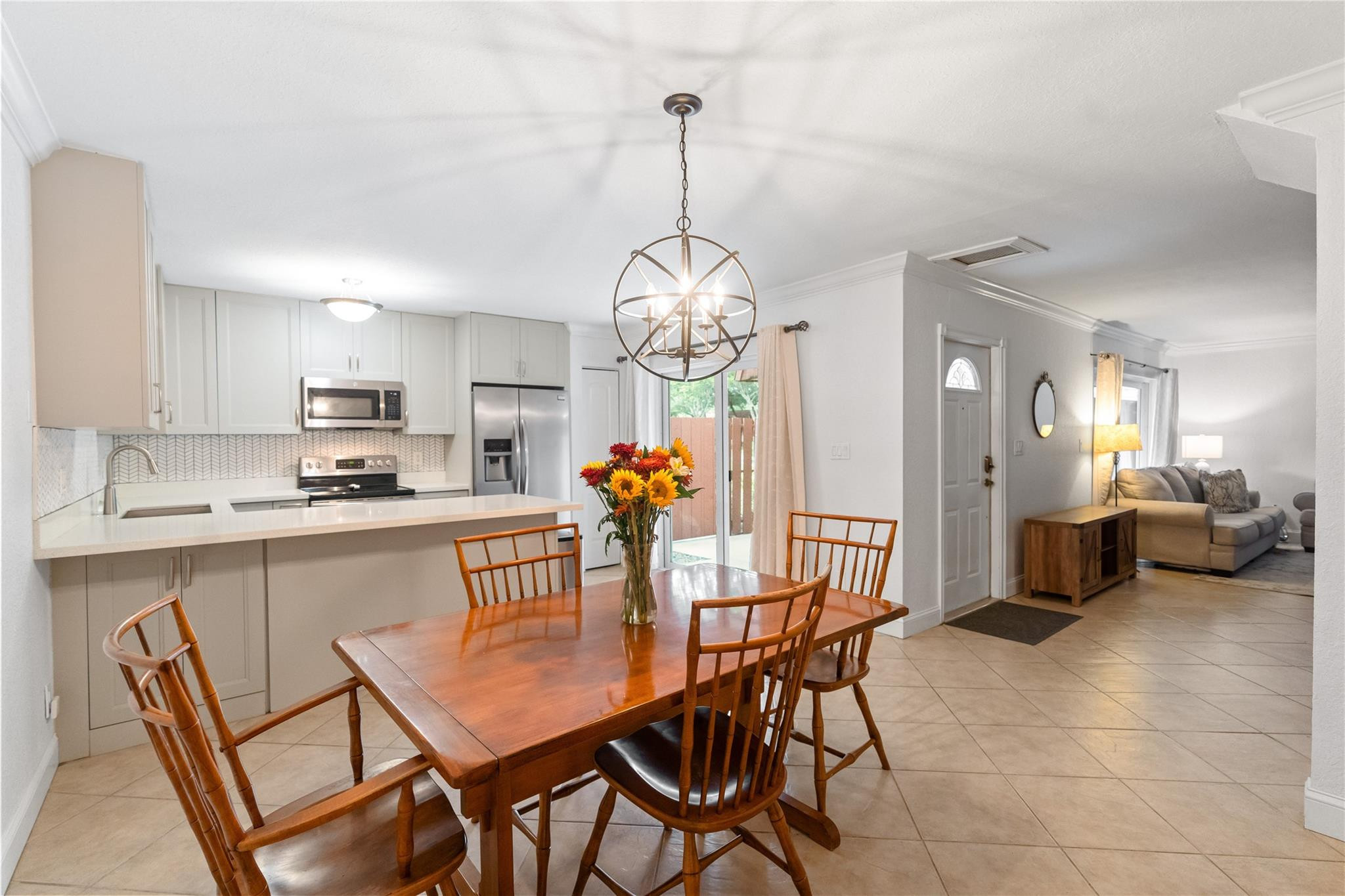 2061 Southwest 90th Avenue, Unit B17 Davie, FL 33324 - Photo 15 of 38 a dining room filled chandelier and kitchen view