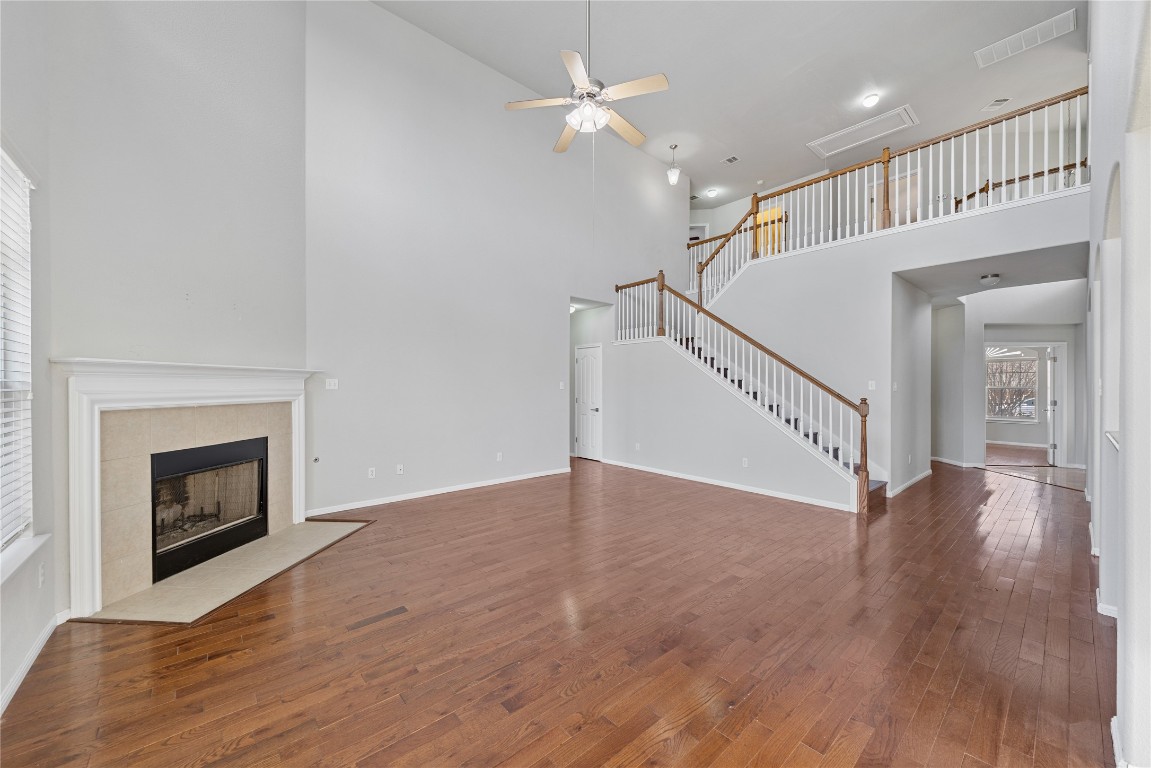 12017 Lansdowne Road Austin, TX 78754 - Photo 6 of 30 a view of an empty room with wooden floor a fireplace and a window