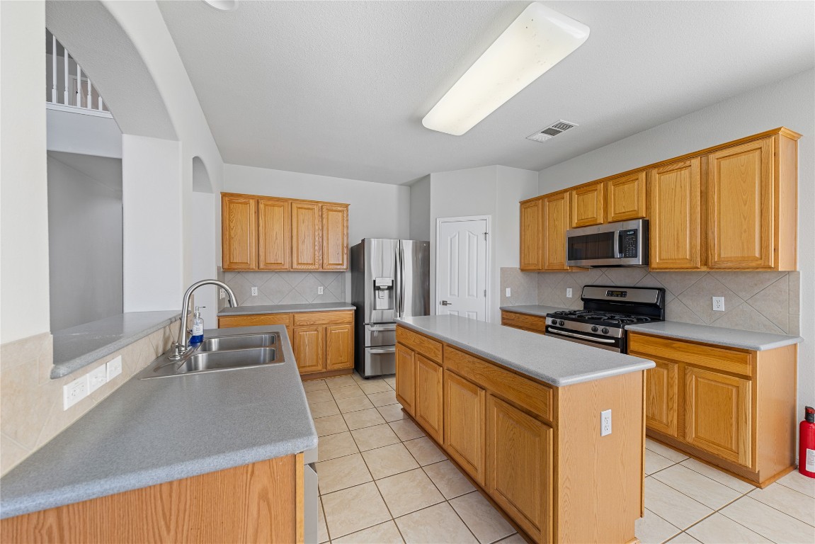 12017 Lansdowne Road Austin, TX 78754 - Photo 9 of 30 a kitchen with stainless steel appliances a stove sink microwave and cabinets