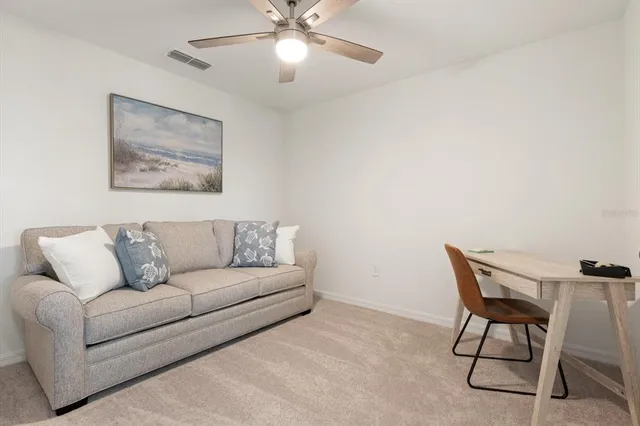 a living room with furniture and a ceiling fan