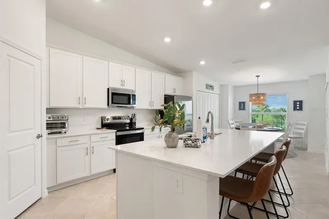 a kitchen with a sink white cabinets and stainless steel appliances