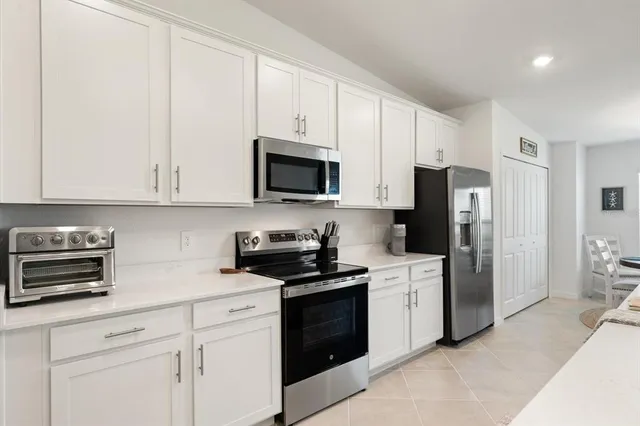 a kitchen with white cabinets and stainless steel appliances
