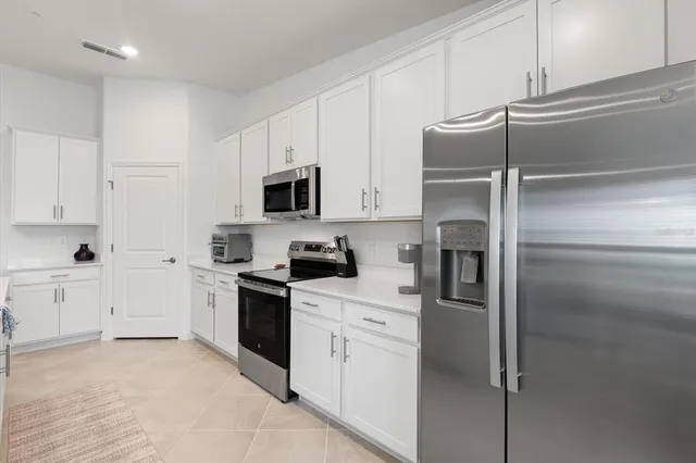a kitchen with cabinets stainless steel appliances and a counter space