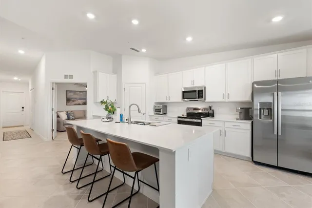 a kitchen with a sink stainless steel appliances and white cabinets