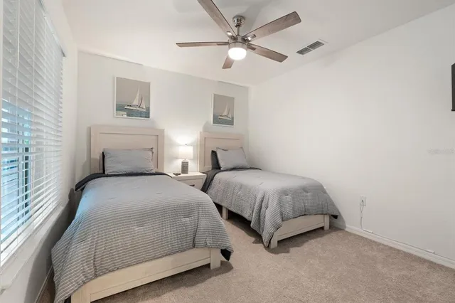 a bedroom with two beds and painting on the wall