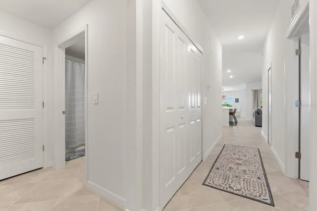 a view of a hallway with a large mirror on a white cabinet