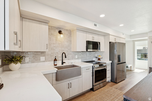 51 East 200 North, Unit 3 Bountiful, UT 84010 - Photo 7 of 27 Kitchen with stainless steel appliances, light wood-style floors, tasteful backsplash, recessed lighting, and light stone counters