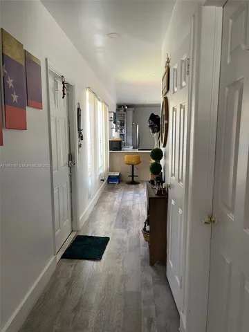 a living room with furniture and a refrigerator