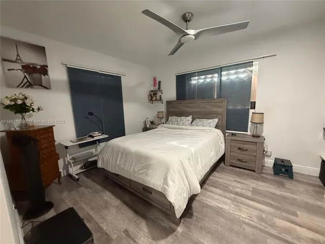 a bedroom with a bed and a flat tv screen on the dresser
