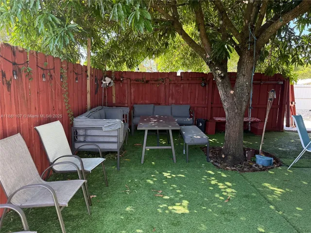 a backyard of a house with table and chairs