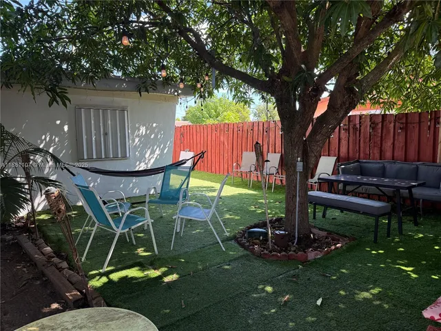 a view of backyard with table and a chairs
