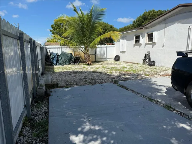 a view of a house with backyard and a tree